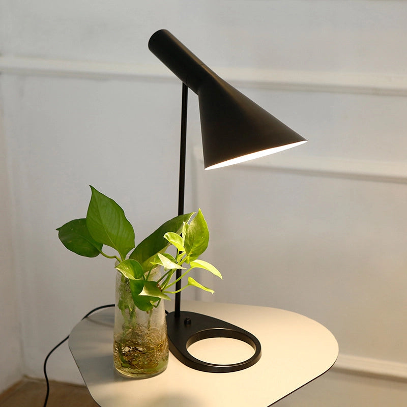 Sleek black metal base with matte finish beside leather-bound notebooks