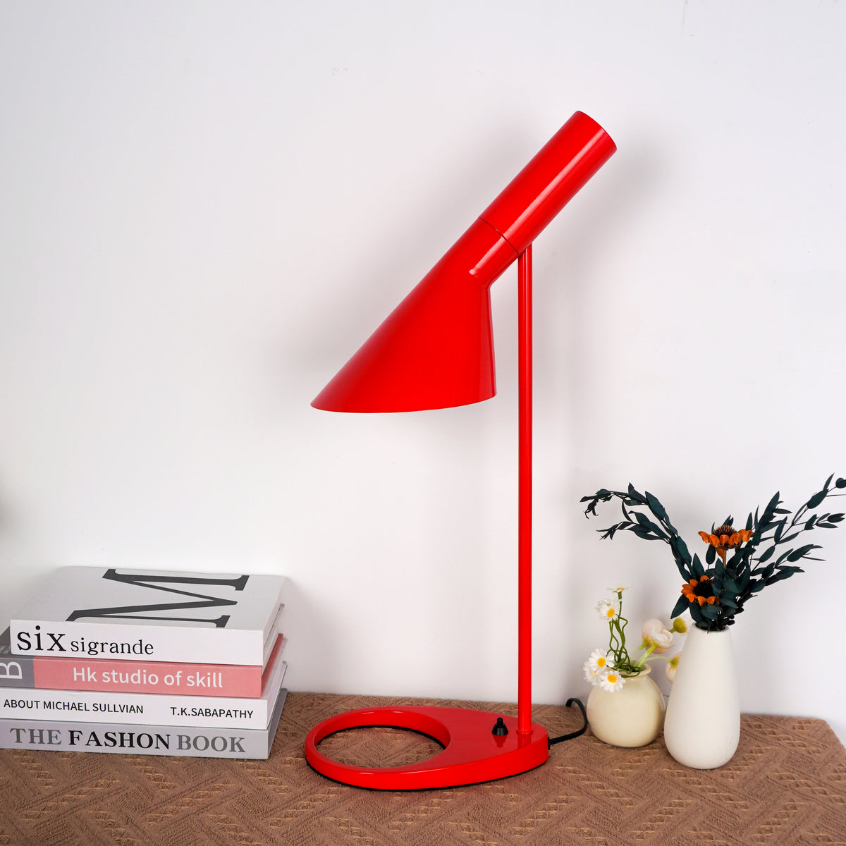 Close-up of textured red linen shade with polished brass switch detail