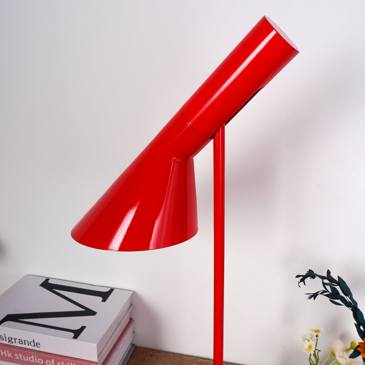 Angular red lamp casting geometric shadows on neutral-colored wall background