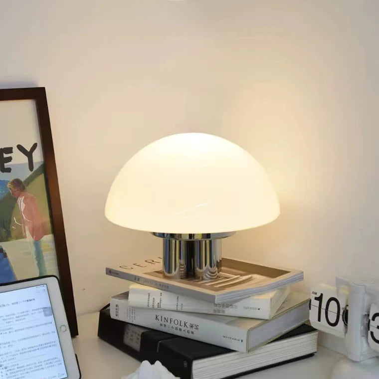 Bauhaus table lamp combines white glass shade and metallic base, merging retro with modern.