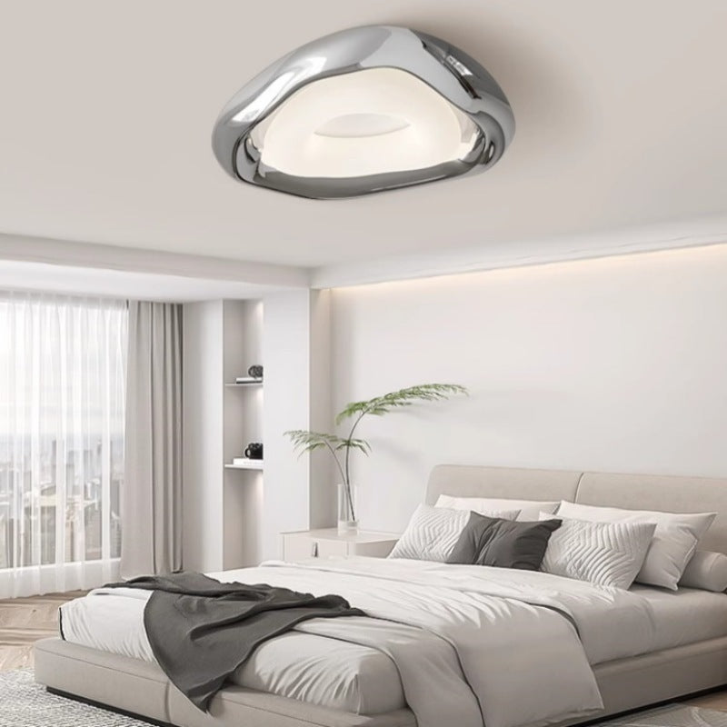 Sleek, artistic ceiling fixture casts soft glow, perfect for modern interiors.