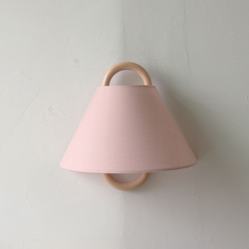 A beech solid wood wall lamp with a light pink lampshade, featuring a clean and modern design.