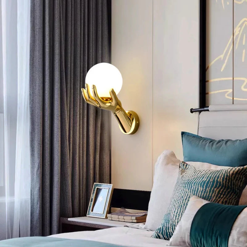 In the warm bedroom, the golden hand-shaped wall lamp softly illuminates, the gray curtain hangs lightly on the side, the bedside pillows are colorful, and the bedside tables are exquisitely arranged.