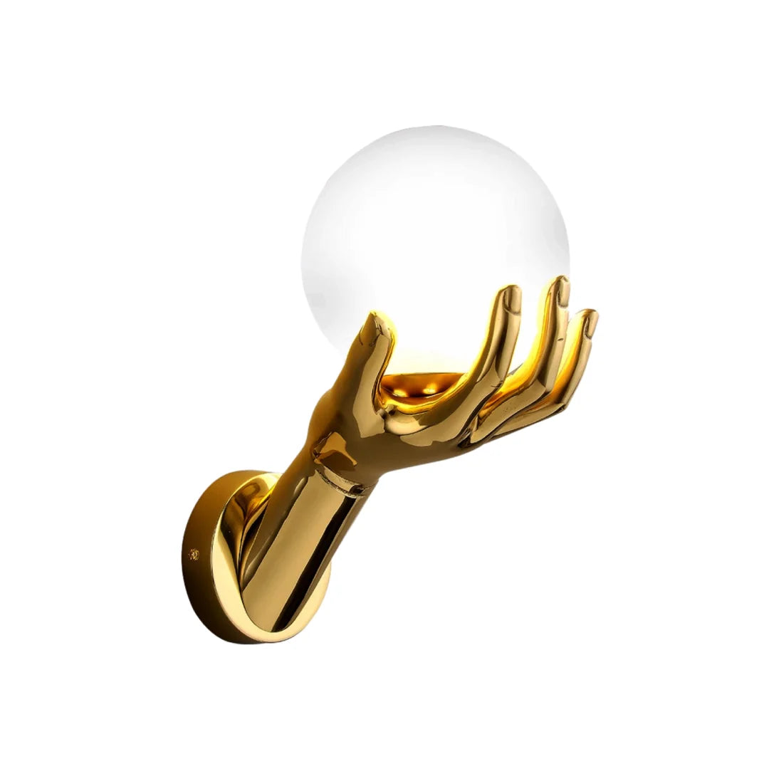 Side view of the golden hand-shaped wall lamp on a white background