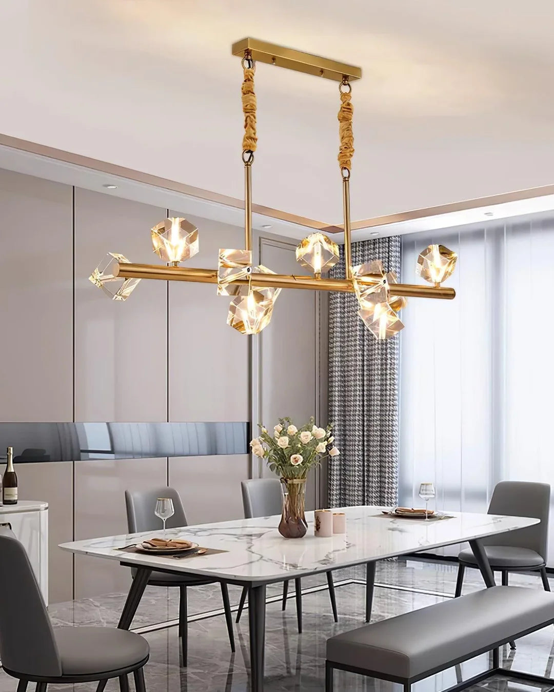 A Polyhedron Crystal Chandelier with a gold body is installed on the dining table.