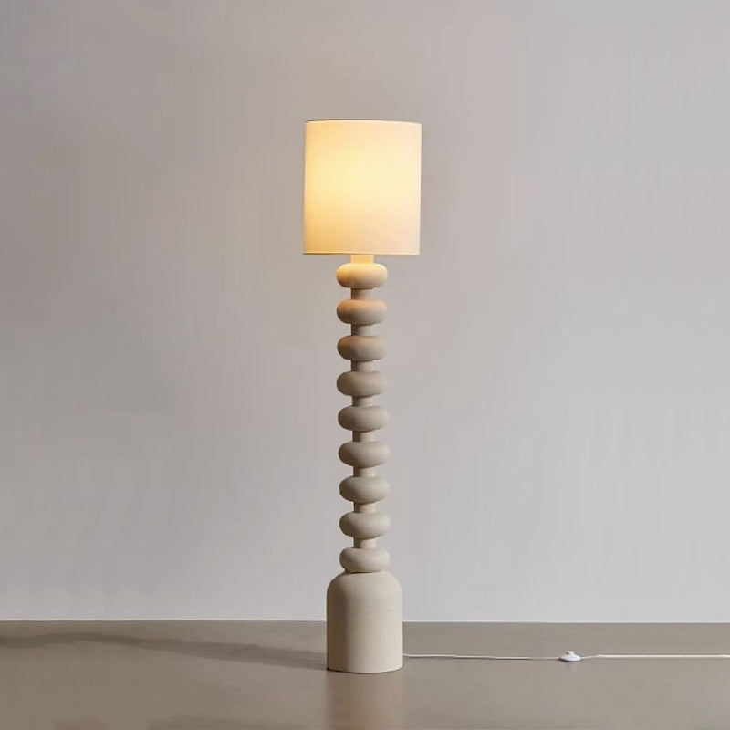 Featuring a resin, layered structure and fabric top, the lamp offers light that suits the space’s stylish, warm design