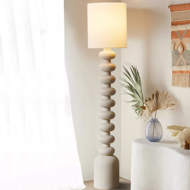 This lamp—resin base with smooth tiers, fabric shade—sends out light that merges seamlessly with the room’s chic-cozy decor.