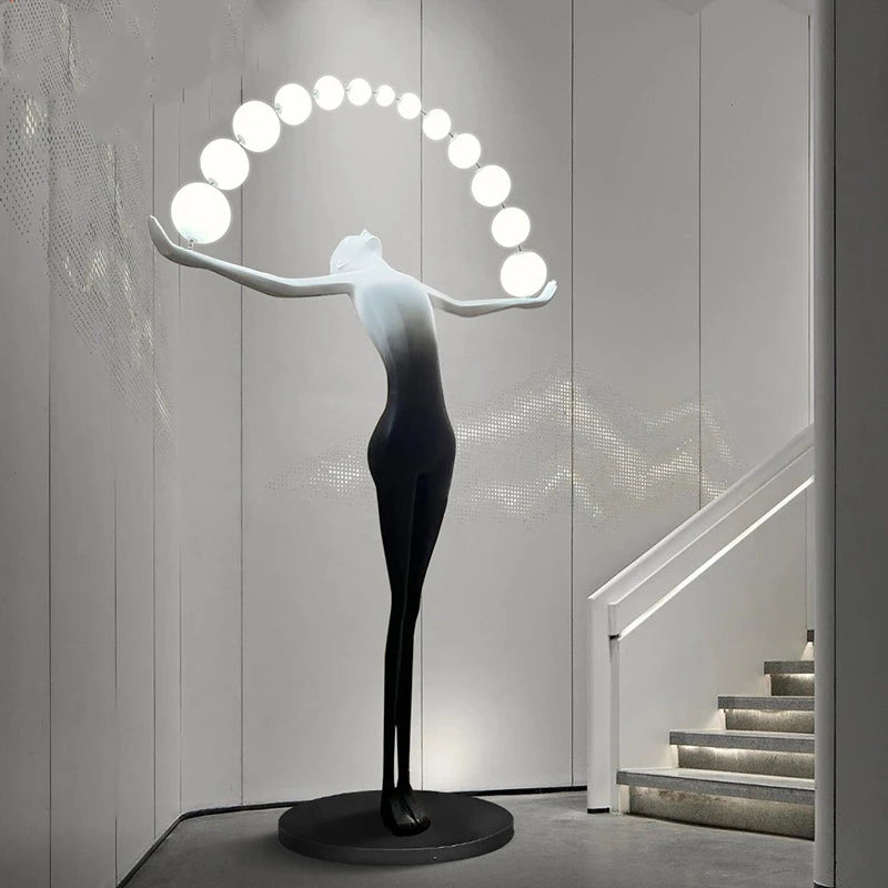 The human sculpture floor lamp emits white light at the staircase