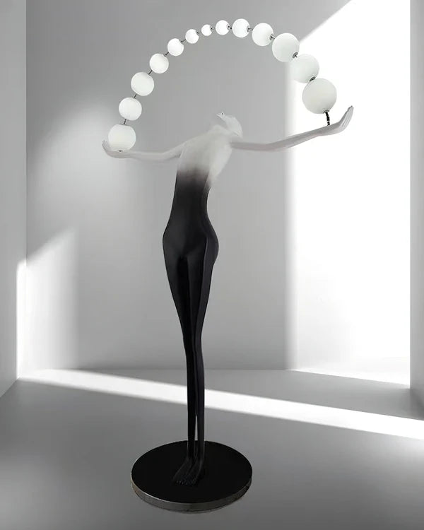 The floor lamp with human arms stretched out has a row of white spherical lamp bodies strung between the arms.