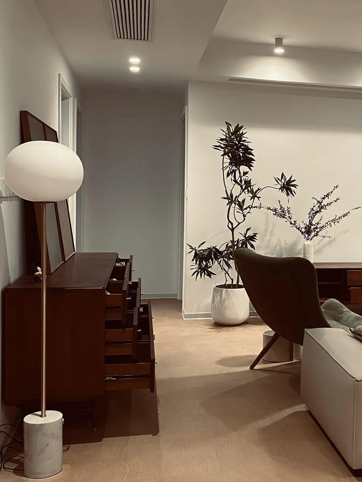 The warm texture and solid and stable Jwda Glass Floor Lamp complement the walnut-colored cabinet