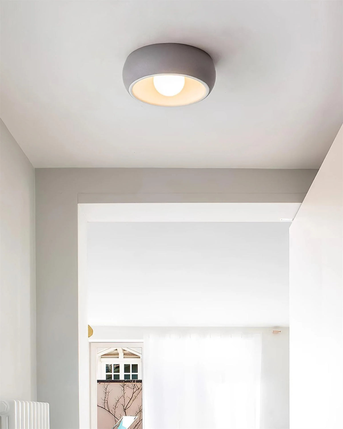 Indoors, light grey ceiling lamps are suspended from the ceiling, and warm light diffuses.