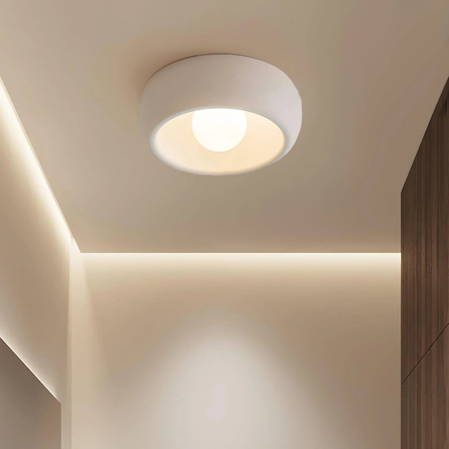 The Kovacs Ceiling Light with a gray and white lampshade is integrated with the ceiling of the aisle