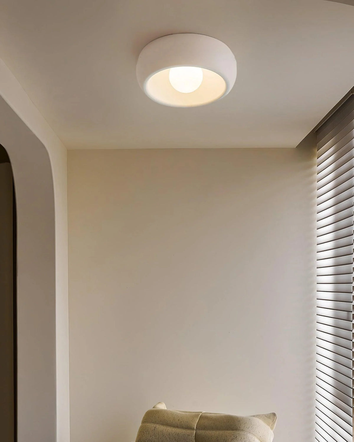 On the ceiling, a white round ceiling lamp stands quietly, spreading soft light quietly.