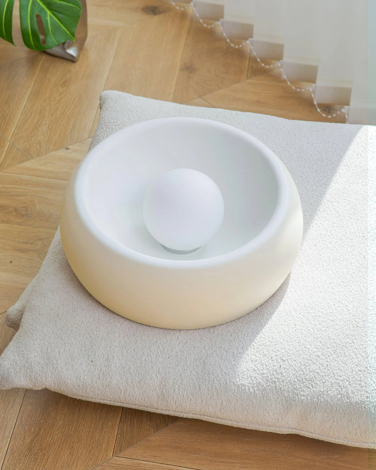 On the light beige cushion, the Kovacs Ceiling Light is quietly placed.