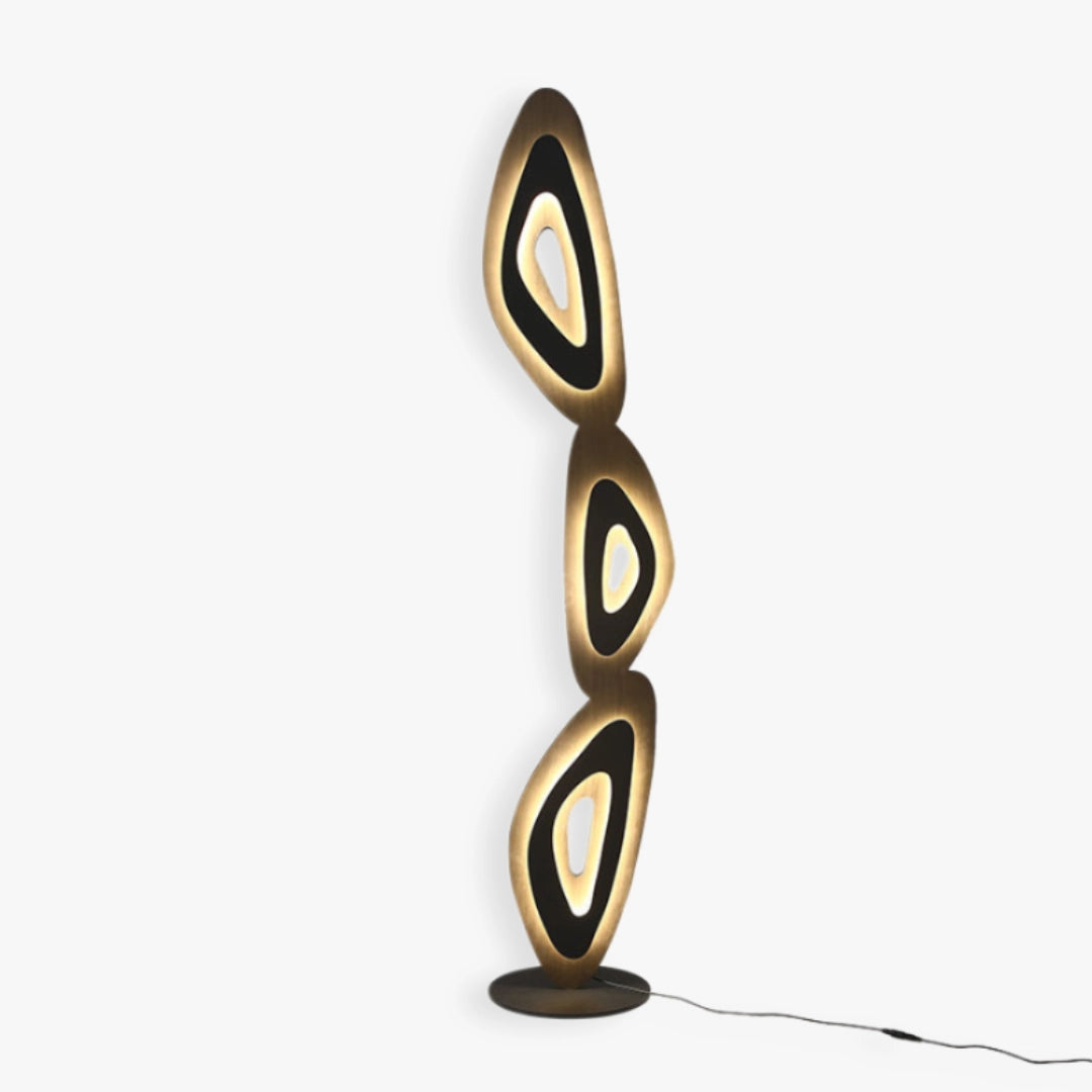 Stylish lamp features layered, oval shapes for ambient room illumination.