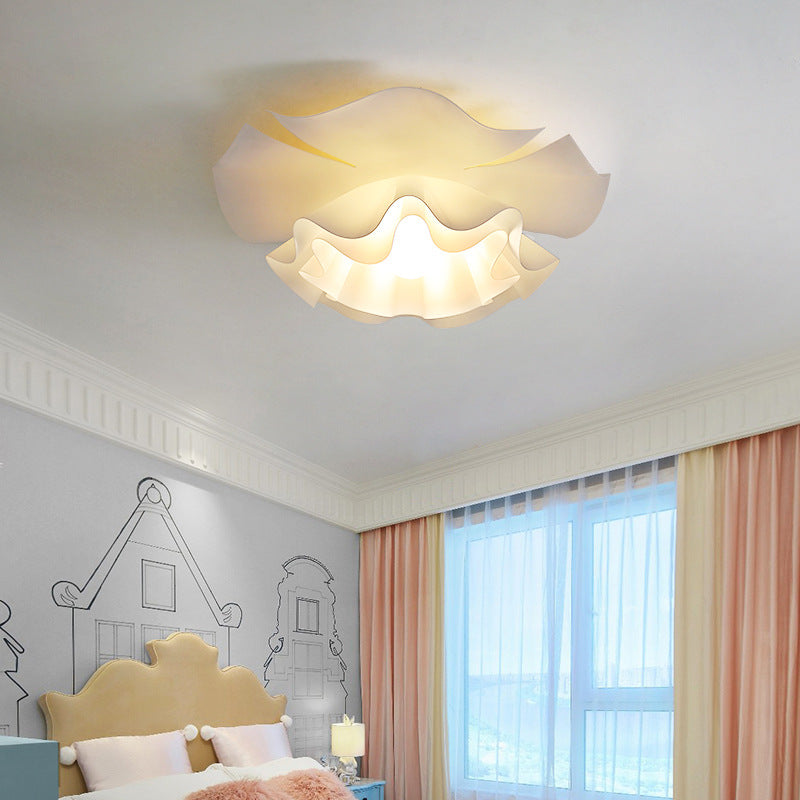 In the bedroom, a unique flower-shaped ceiling lamp hangs on the ceiling.
