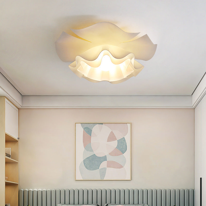 In the bedroom, a soft flower-shaped ceiling light hangs elegantly on the ceiling.