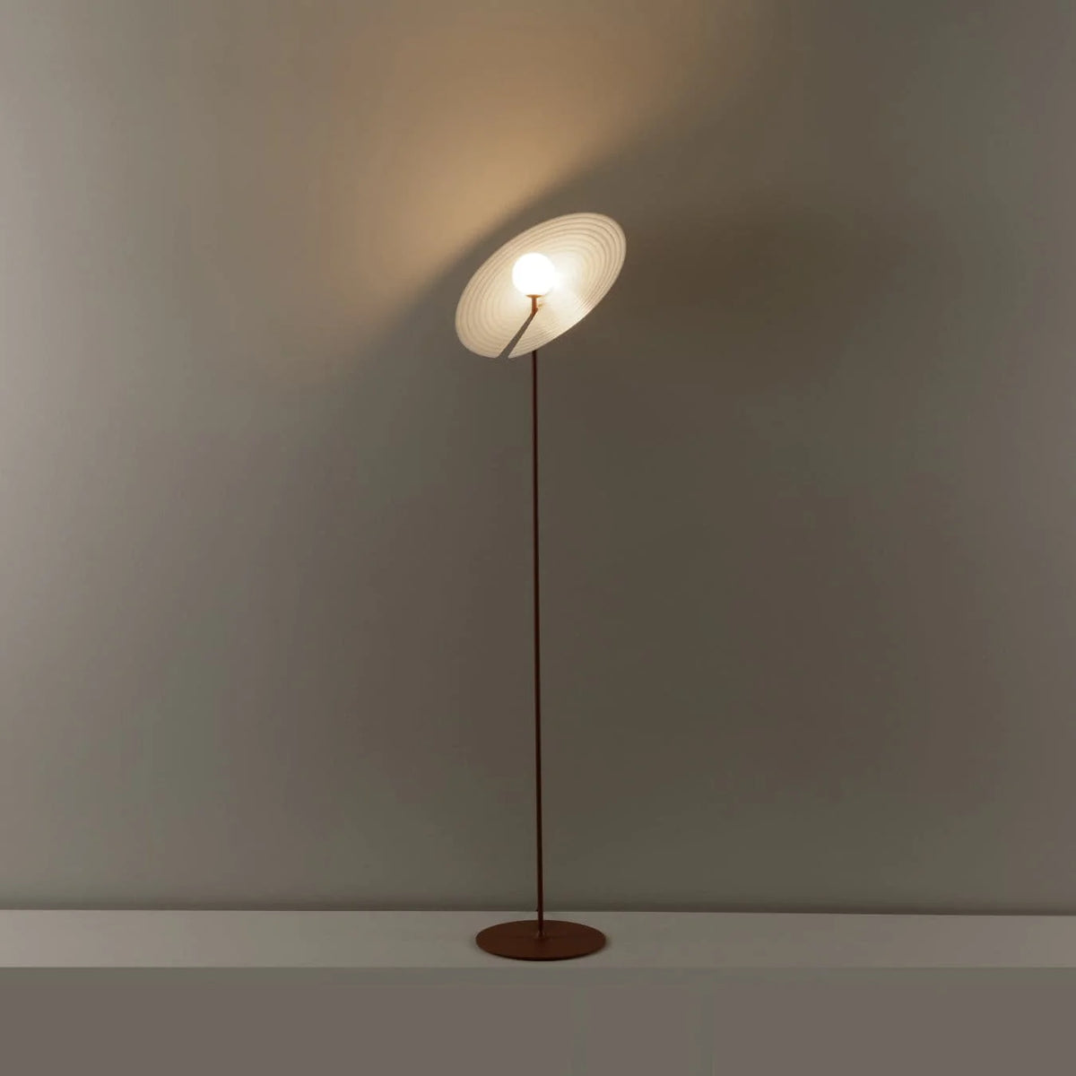 Creative floor lamp design: record-shaped shade spreads gentle light, balancing decor and functionality.