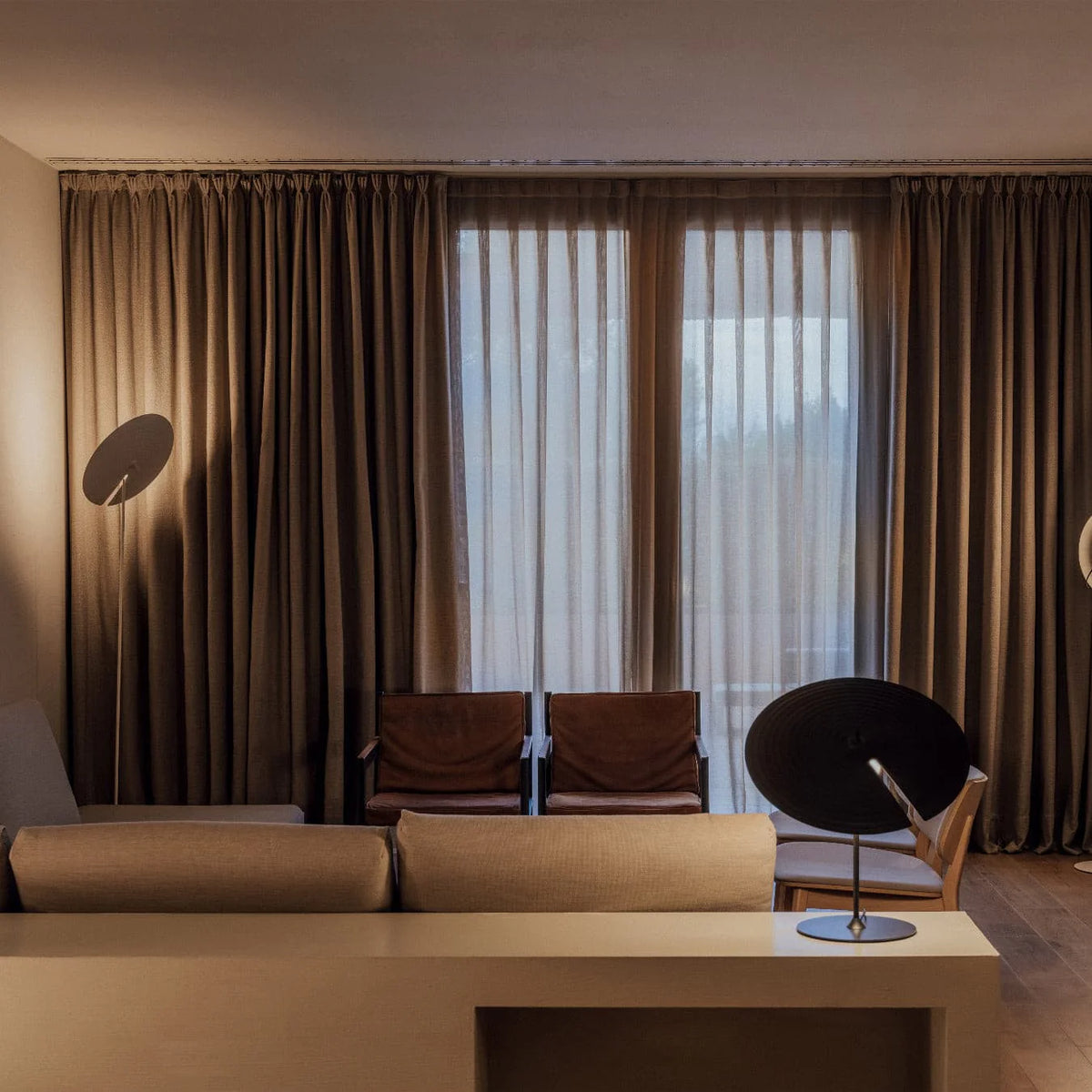 Unique circular-shade floor lamp emits soft light, crafting a cozy corner atmosphere effortlessly.