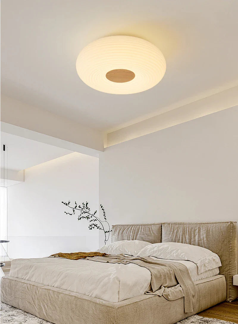 Simple cream round light enhances bedroom’s cozy atmosphere.