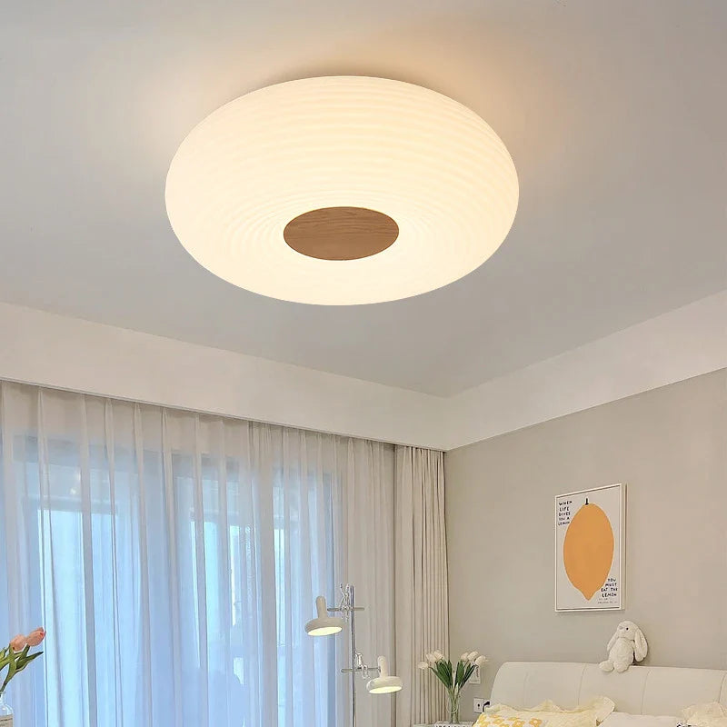 Soft-glow round ceiling light brightens bedroom, harmonizes with decor.