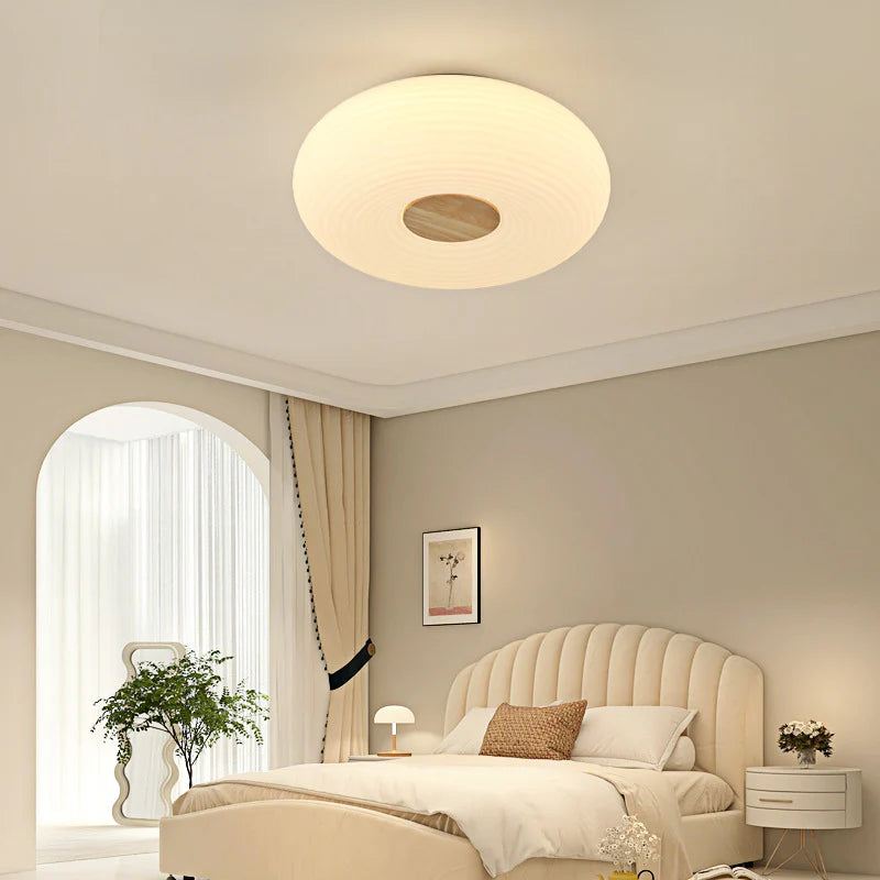 Round cream light creates warm vibe above bedroom area.