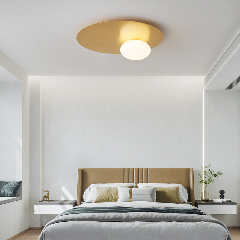 The golden style elliptical ceiling lamp is in the bedroom with its matching style