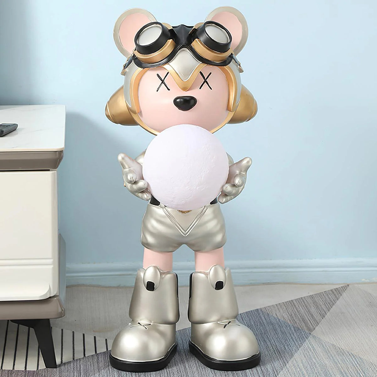 In the interior space with light blue walls, a silver-gold bear floor lamp stands quietly.