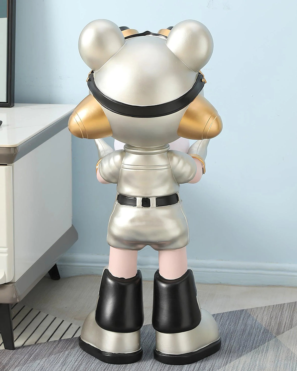 In a corner of the room, a silver-gold resin bear-shaped floor lamp stands with its back to the camera.