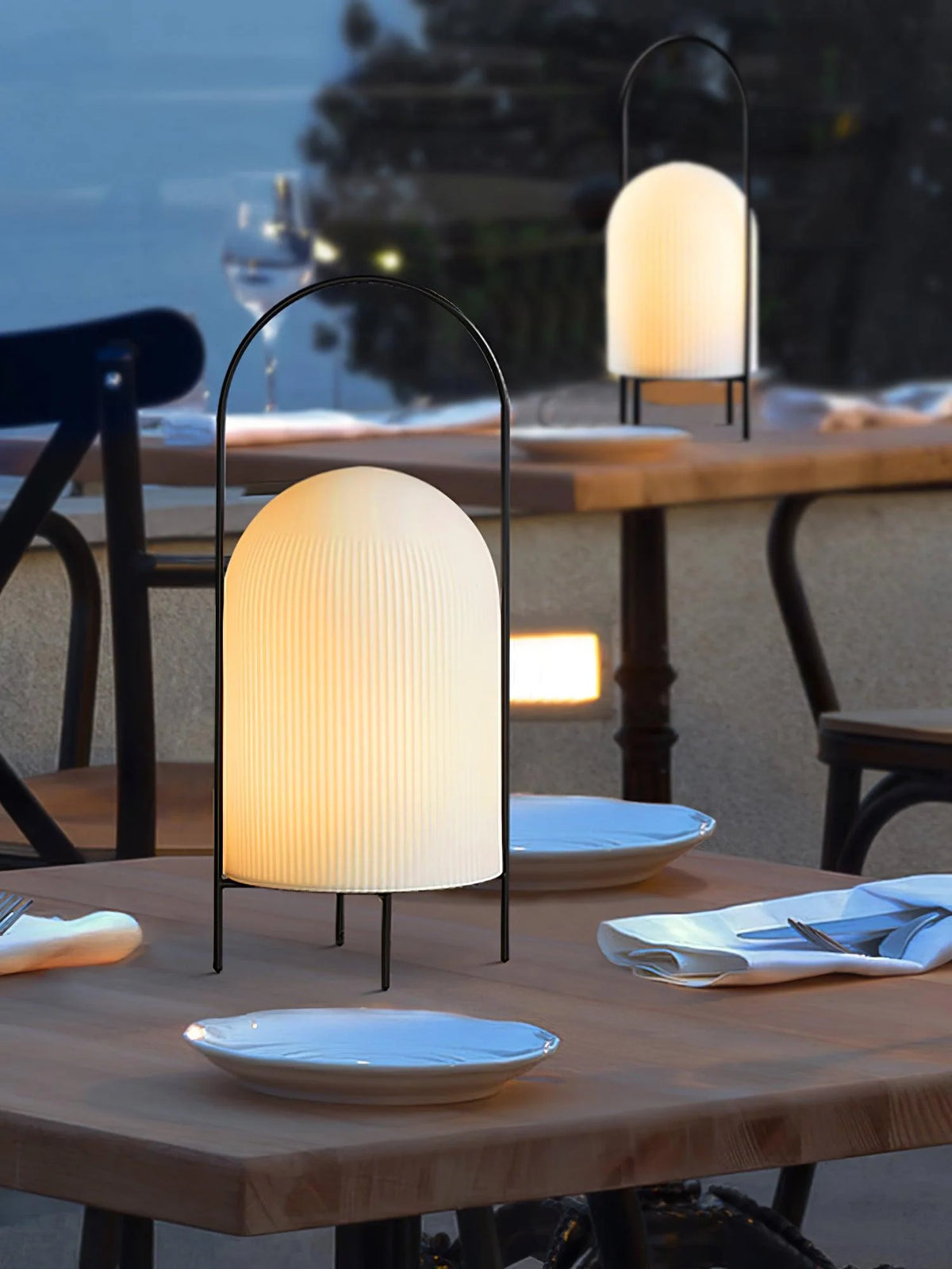 Glass ghost table light illuminating a vintage-inspired bookshelf decor.