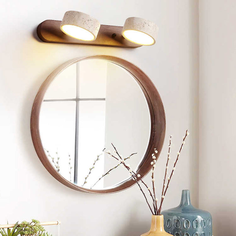 Stylish wall light: dual travertine shades on wood base, casting warm ambient glow.