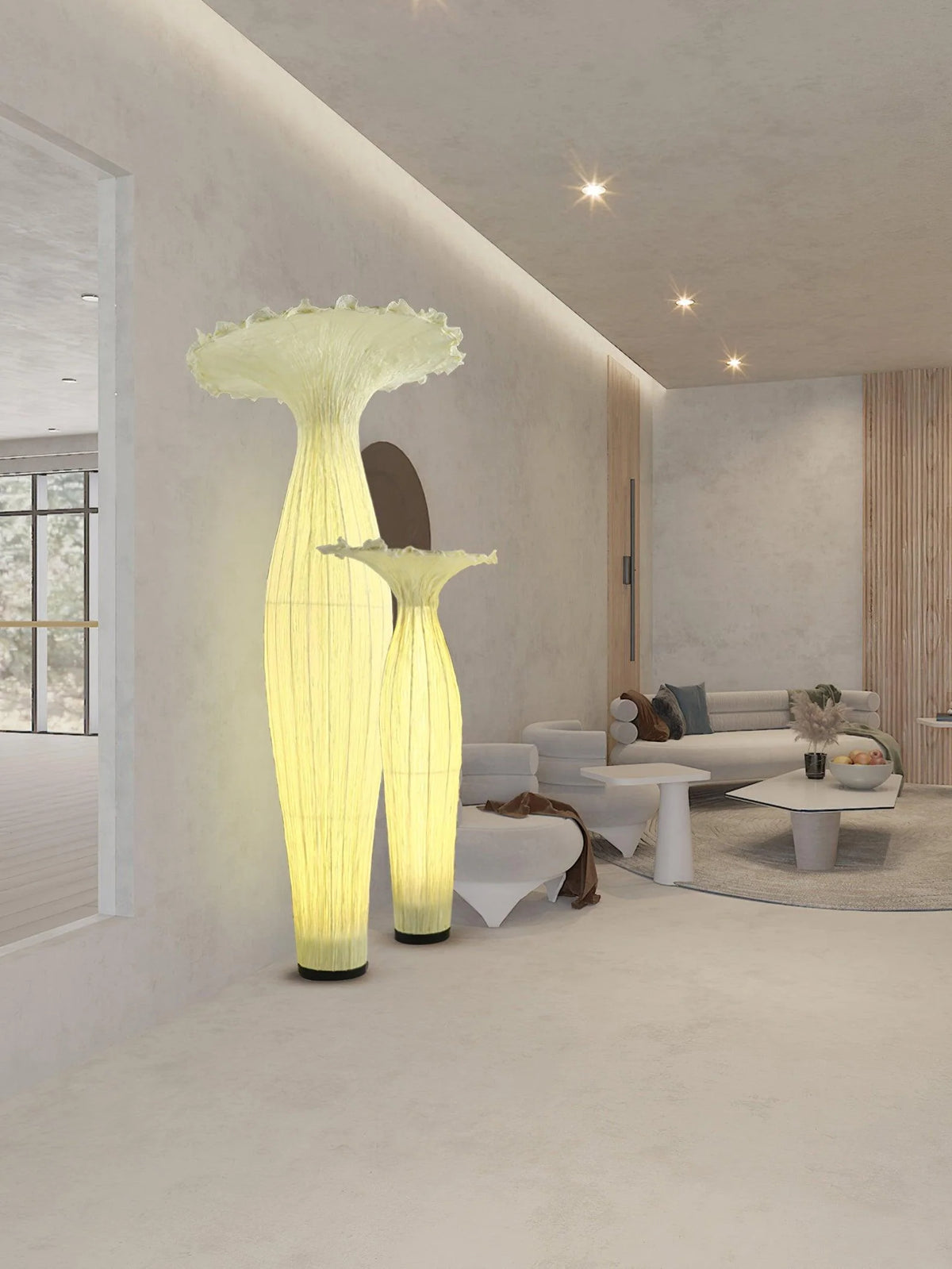 Two sizes of vase floor lamps are placed next to the low sofa.