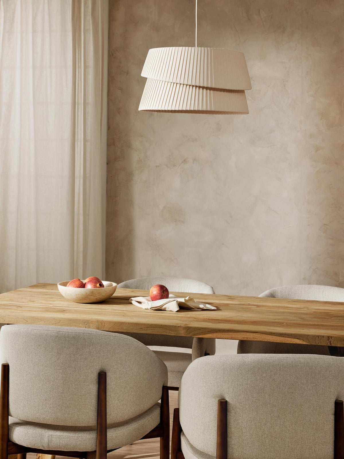 In the dining room scene, a light beige chandelier hangs over the dining table, casting a soft halo on the rustic wooden table.