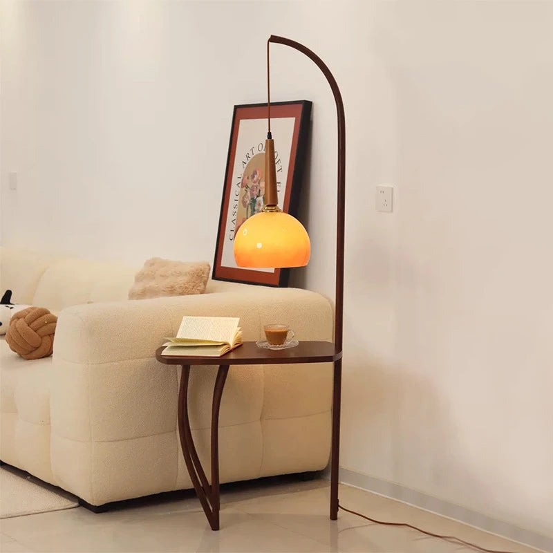 Durable tripod base floor lamp with grapefruit inspired glass cover and storage space