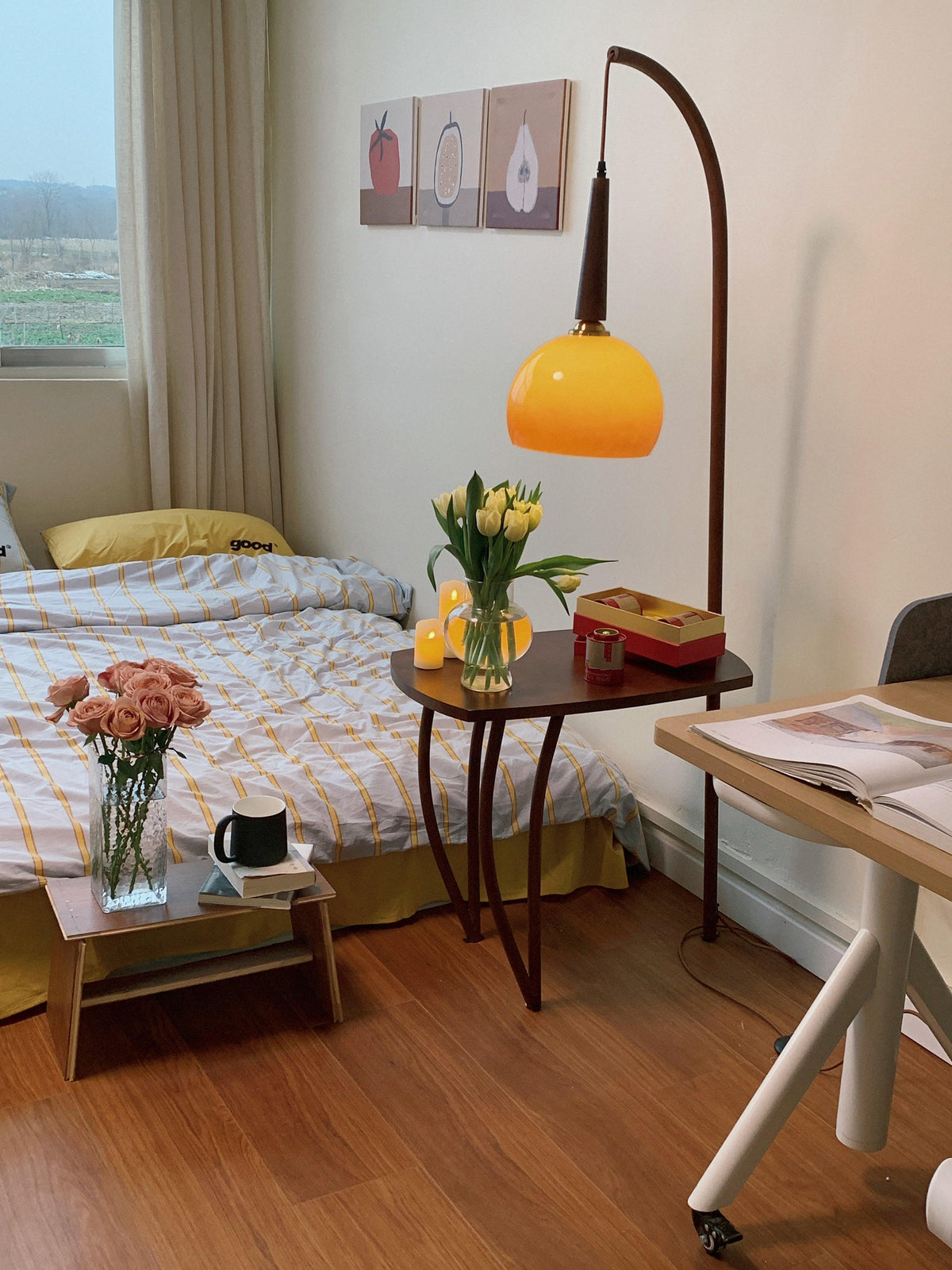 Cozy bedroom setup: durable tripod-base floor lamp with grapefruit-inspired glass shade and shelf