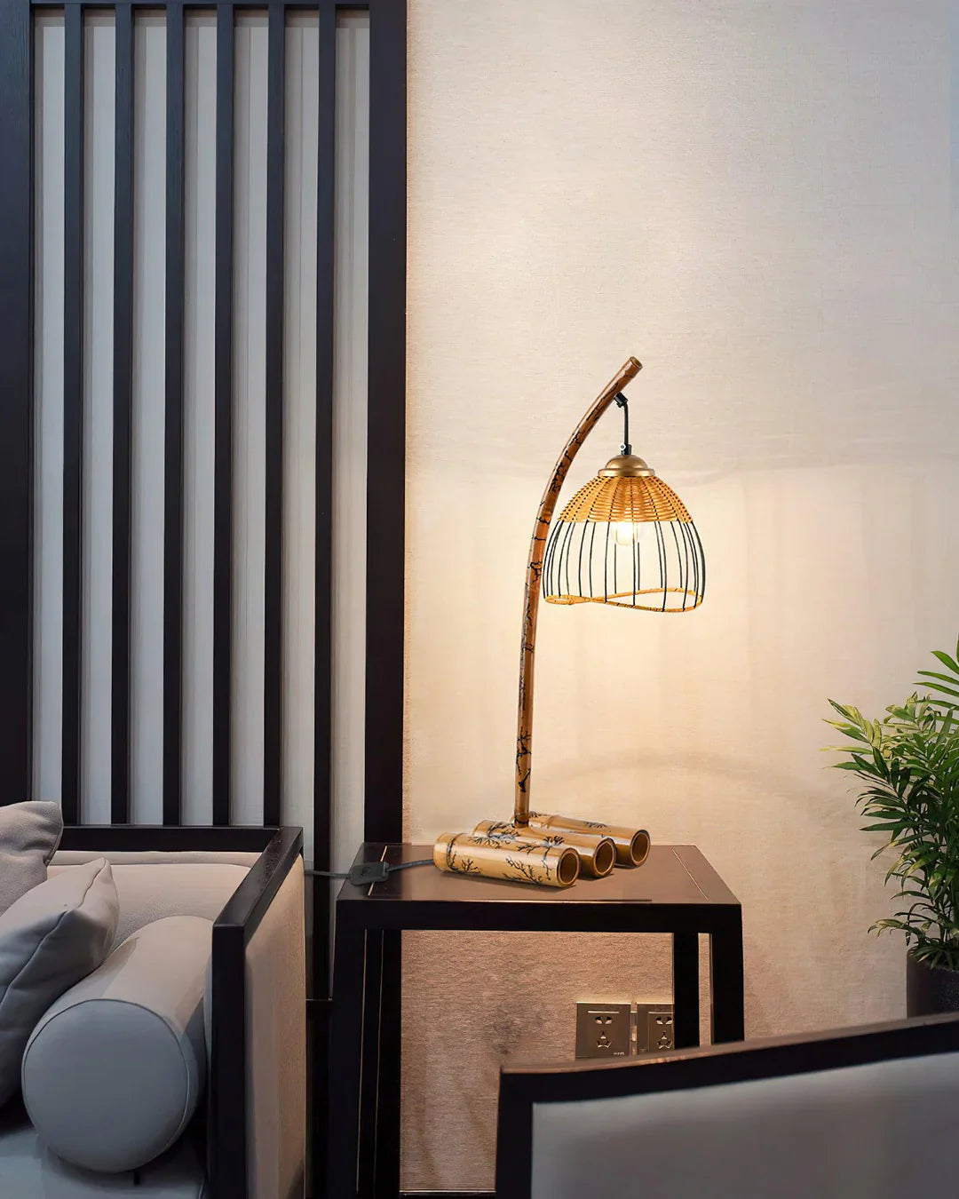In a corner of the room, a bamboo table lamp stands on a simple side table, with a curved lamp pole and a rattan lampshade, and warm light is gently sprinkled.