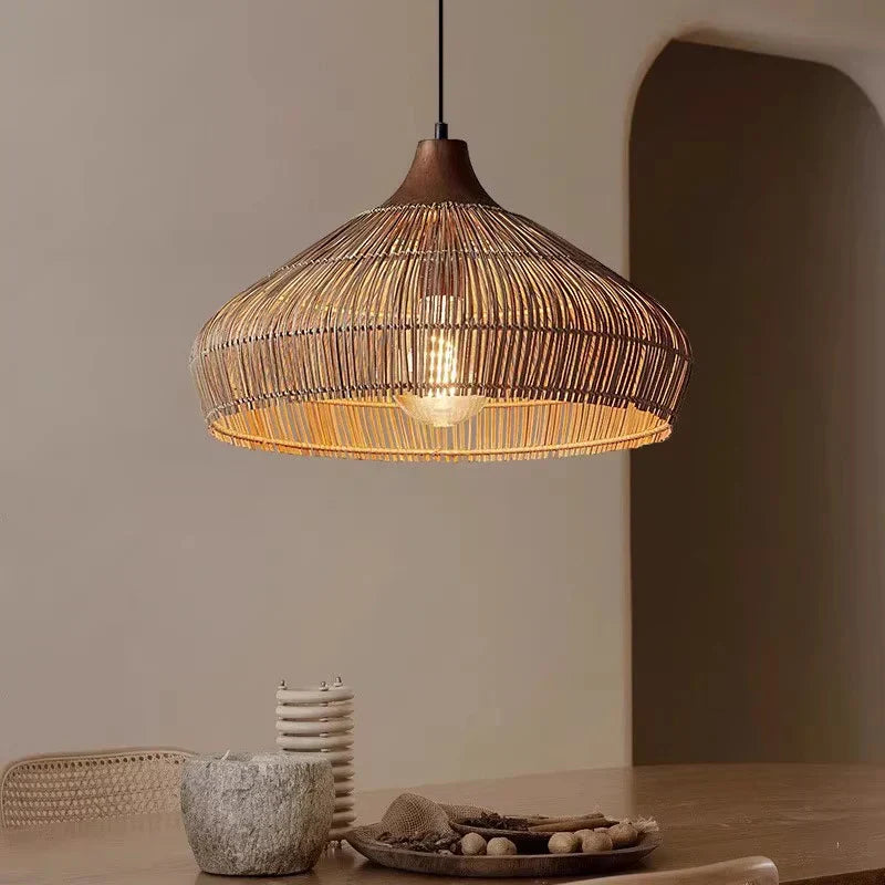 Rattan woven pendant light hanging over dining table in boho style room