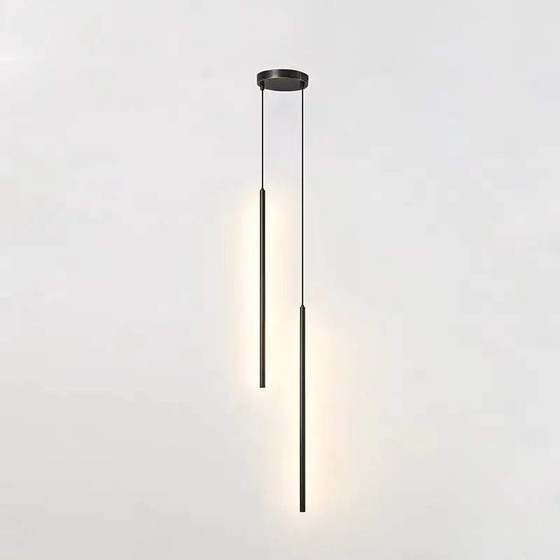 Two light brushed gold staggered cylinder pendant lights with warm downward glow