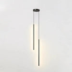 Two light brushed gold staggered cylinder pendant lights with warm downward glow