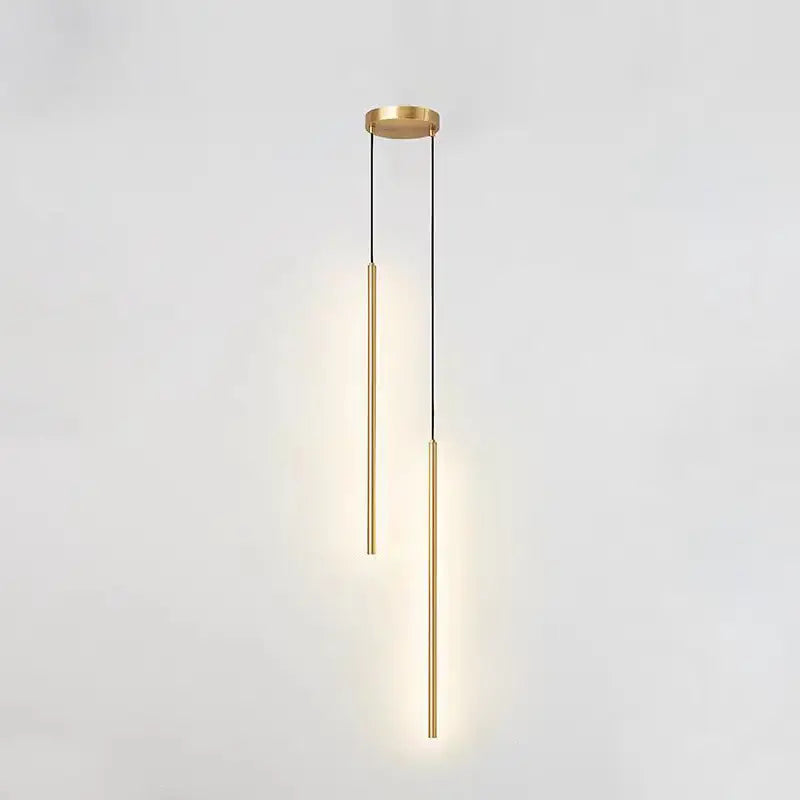 Two light matte black staggered cylinder pendant lamps glowing on white backdrop