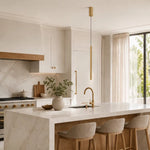 Single brass tube pendant light hanging over luxury marble kitchen island with sink