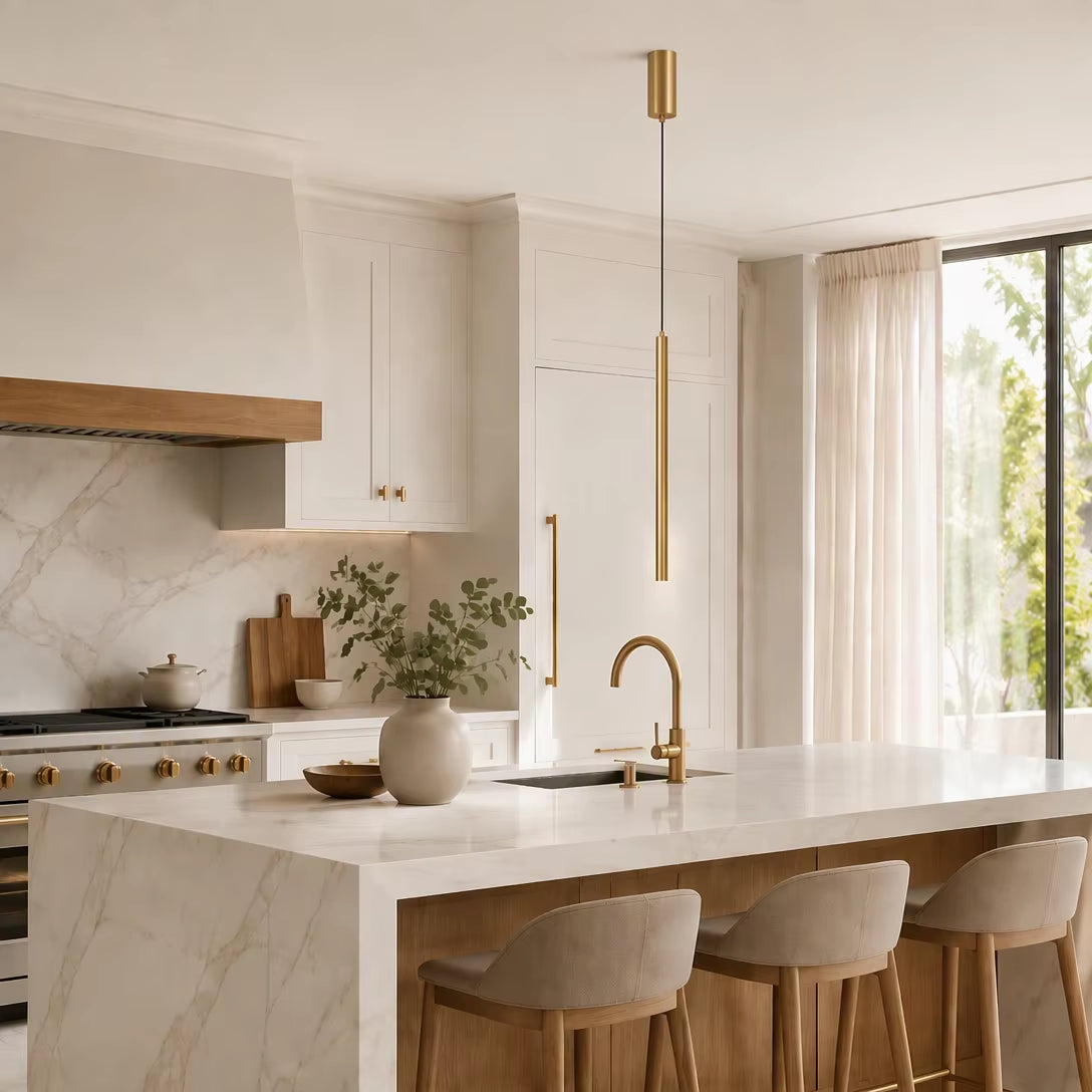 Single brass tube pendant light hanging over luxury marble kitchen island with sink