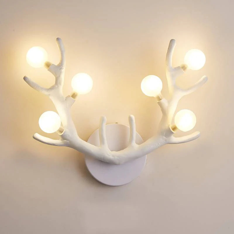 White resin antler sconce creating soft shadows in a monochromatic bathroom vanity area.