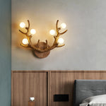 Antler-shaped wall lamp in brown resin, paired with reclaimed wood furniture for a farmhouse aesthetic.