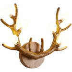 Matte-finish antler wall lamp mounted beside a mirror for functional yet artistic entryway lighting.