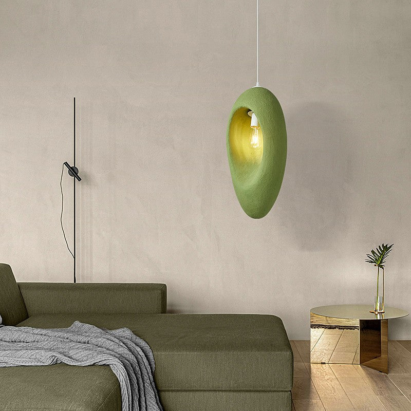 single glowing avocado pendant light hanging above linen sectional sofa, textured plaster wall & gold side table modern wabi-sabi living room