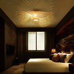 Bamboo Wave Ceiling Lamp: Woven bamboo light (curved design) casting warm patterns in a cozy hotel bedroom.