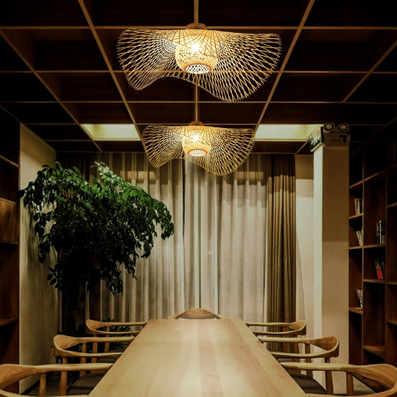 Bamboo Wave Pendant Lamps: Woven bamboo fixtures (curved design) casting warm light patterns over a wooden dining table in a cozy, natural-themed space.