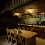 Bamboo Wave Ceiling Lamps: Woven bamboo lights with curved design, casting warm patterns in a rustic dining space.