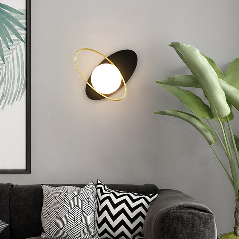 Wall lamp inspired by the galaxy featuring a circular white glass light.